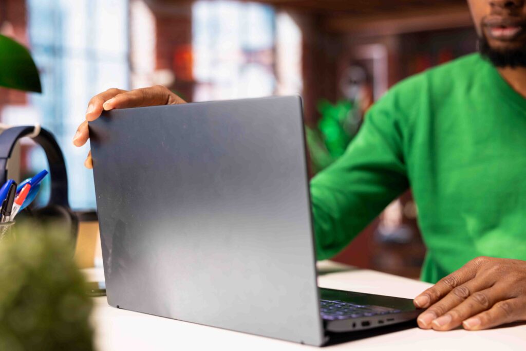 freelancer sitting at desk in home office using laptop, close up